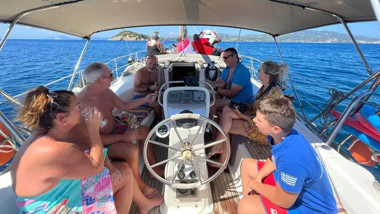 Guests around the helm, with the island behind